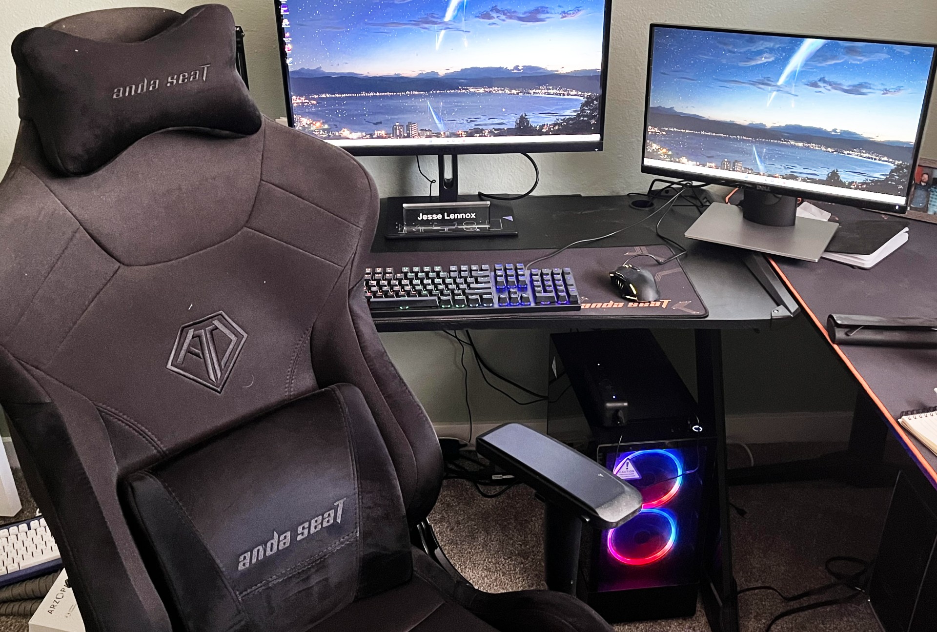A PC gaming desktop setup with two monitors and a gaming chair.